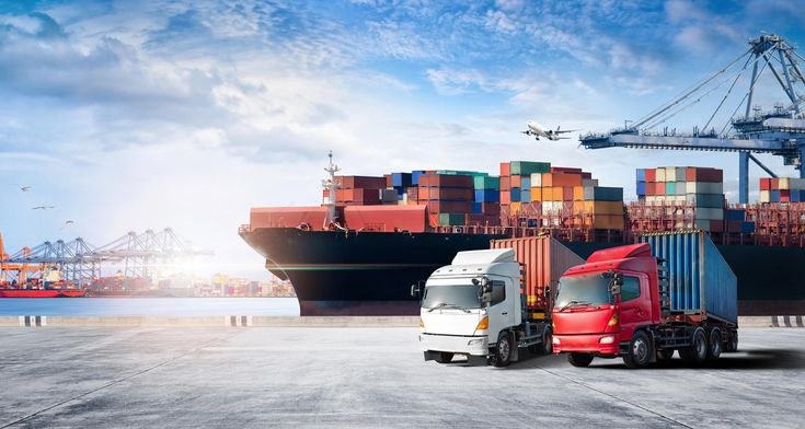 Container ship, cargo trucks and port cranes at a shipping terminal
